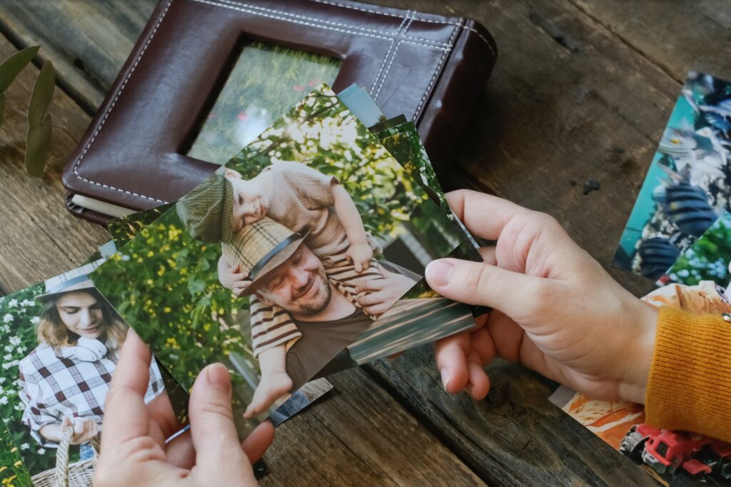 Photo printing, family memories. Woman looks at printed photos for family picture album.